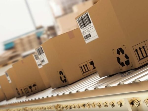 Packed courier on production line against  cardboard boxes in warehouse